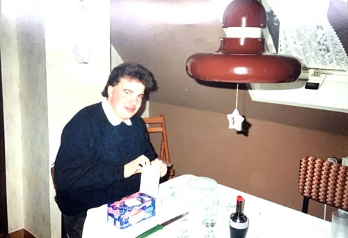 Christian sitzt als junger Erwachsener an einem Tisch. Copyright: privat