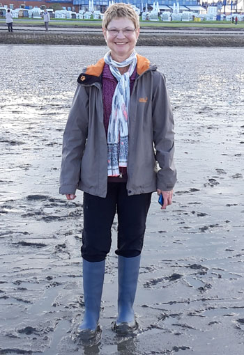 Simone steht mit Gummistiefeln im Wattenmeer. / Copyright: Simone Schmidt