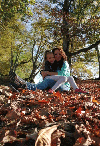 Tamara kuschelt mit ihrer Tochter im Laub in einem Wald. / Copyright: Tamara Maier