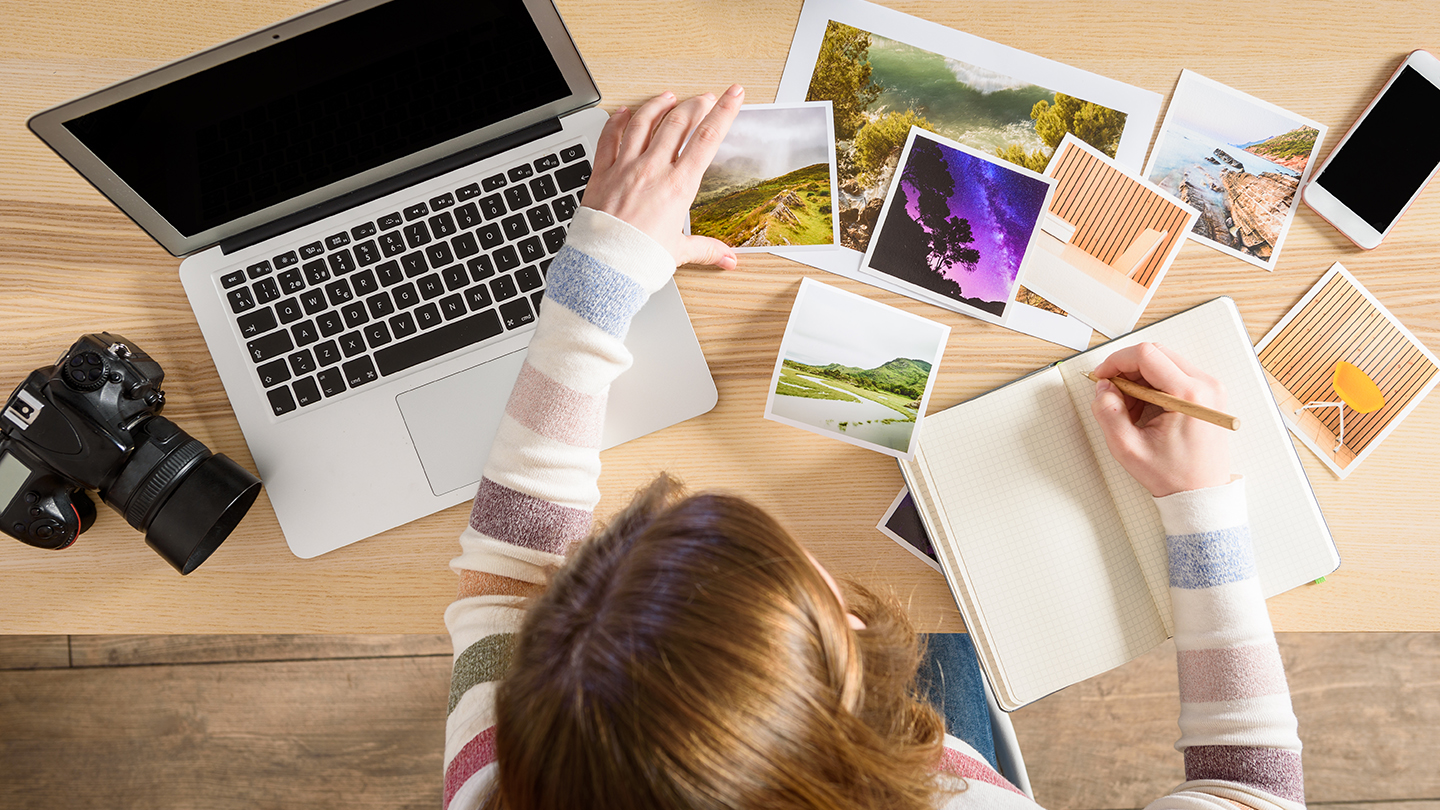 Ein Mädchen sortiert Polaroidfotos und macht sich Notizen; Copyright: iStock/pepmiba