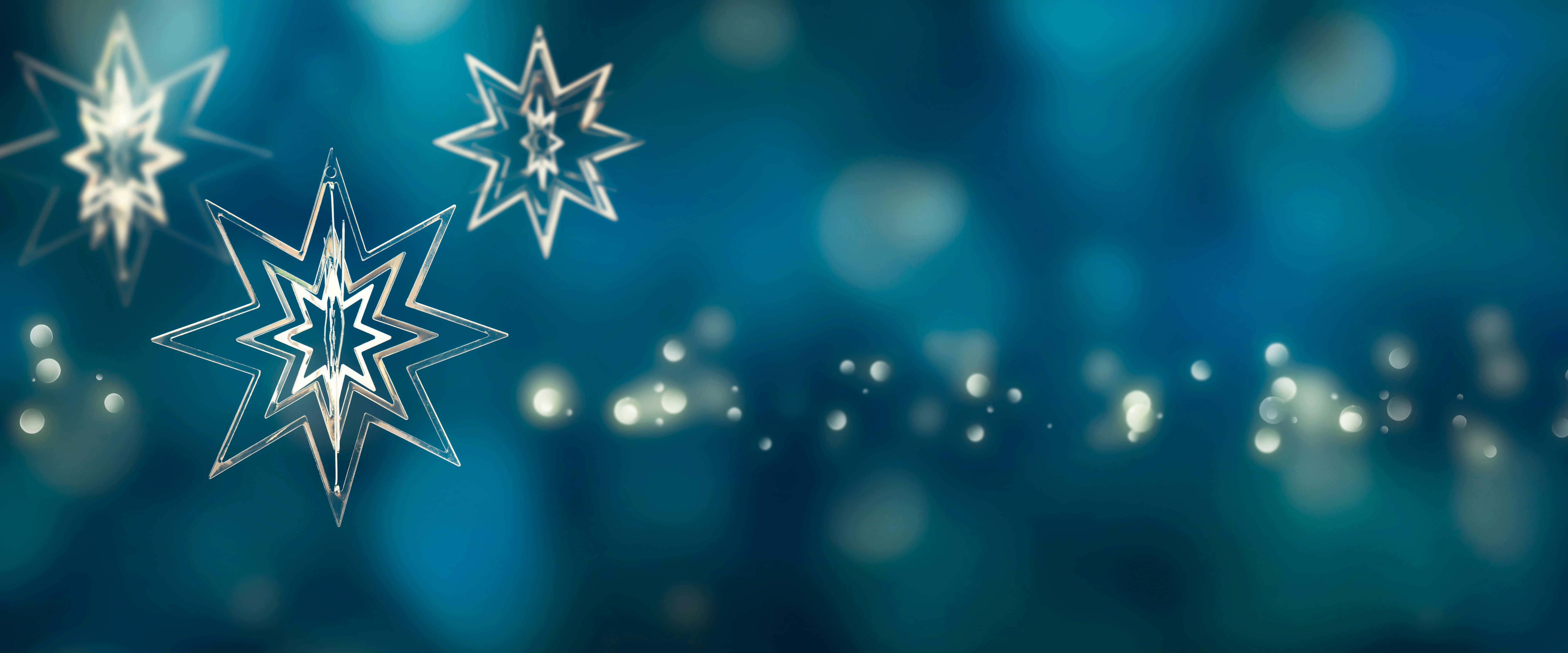 Goldene Sterne auf blauem Hintergrund vermitteln weihnachtliche Stimmung. Copyright: iStock/winyuu