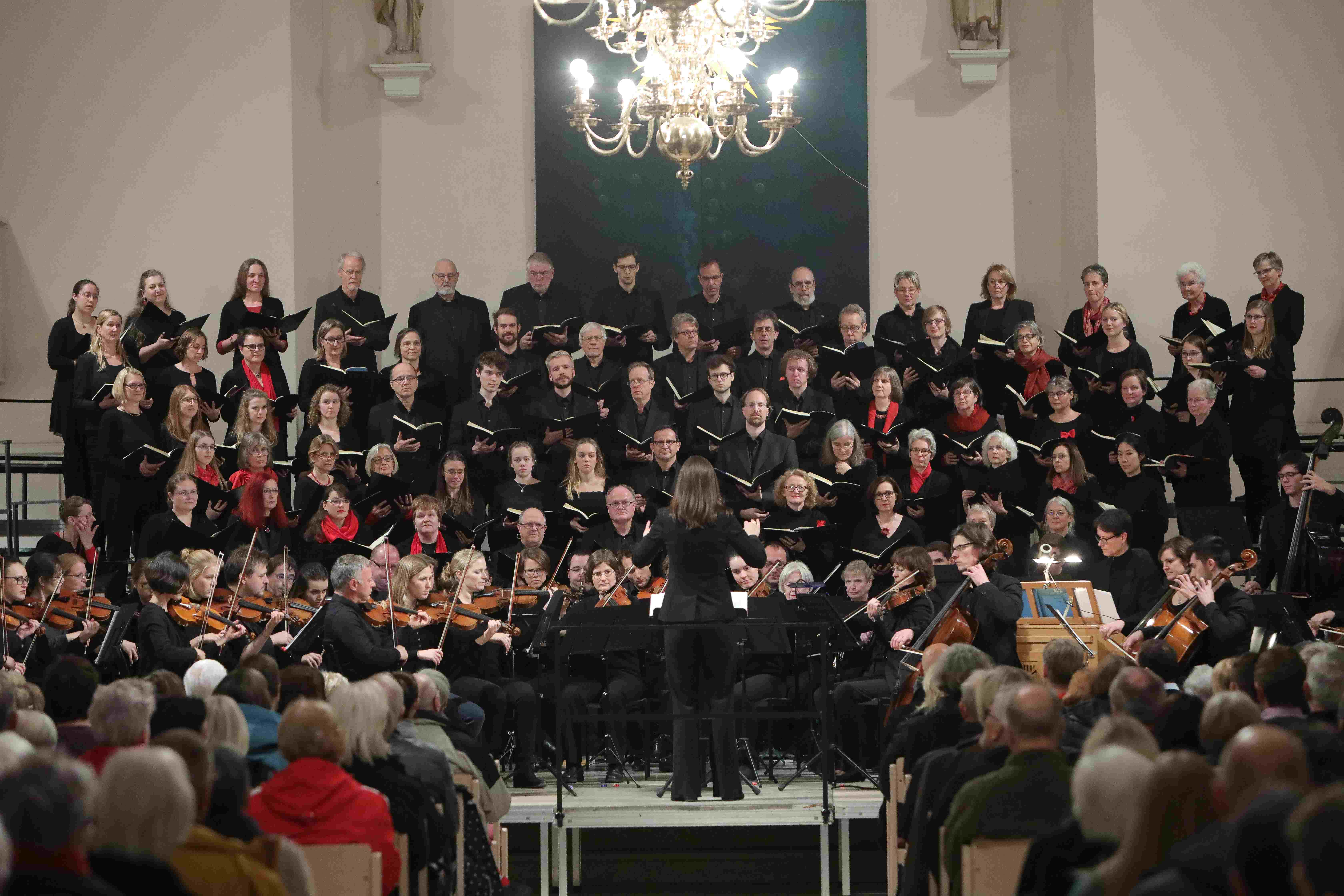Die Sängerinnen und Sänger des Chors der MHH bei einem Auftritt in schwarzer Kleidung.