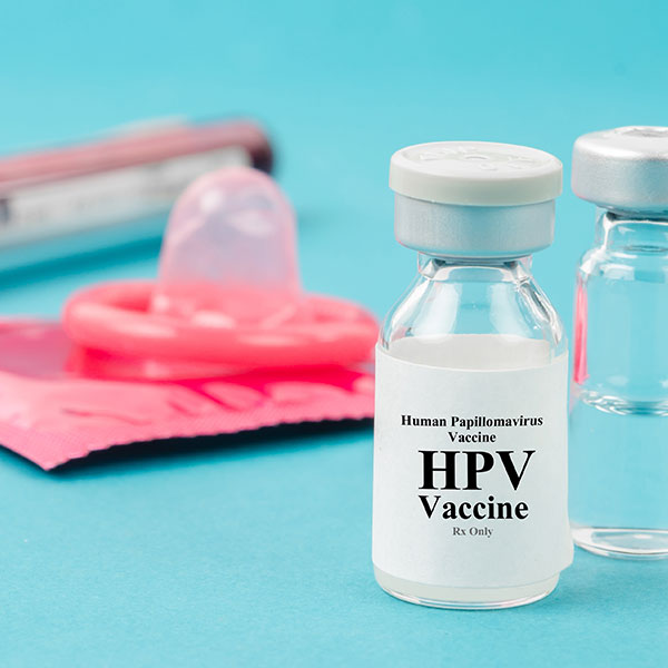 Abbildung mit HPV-Impfstoff und Kondom
