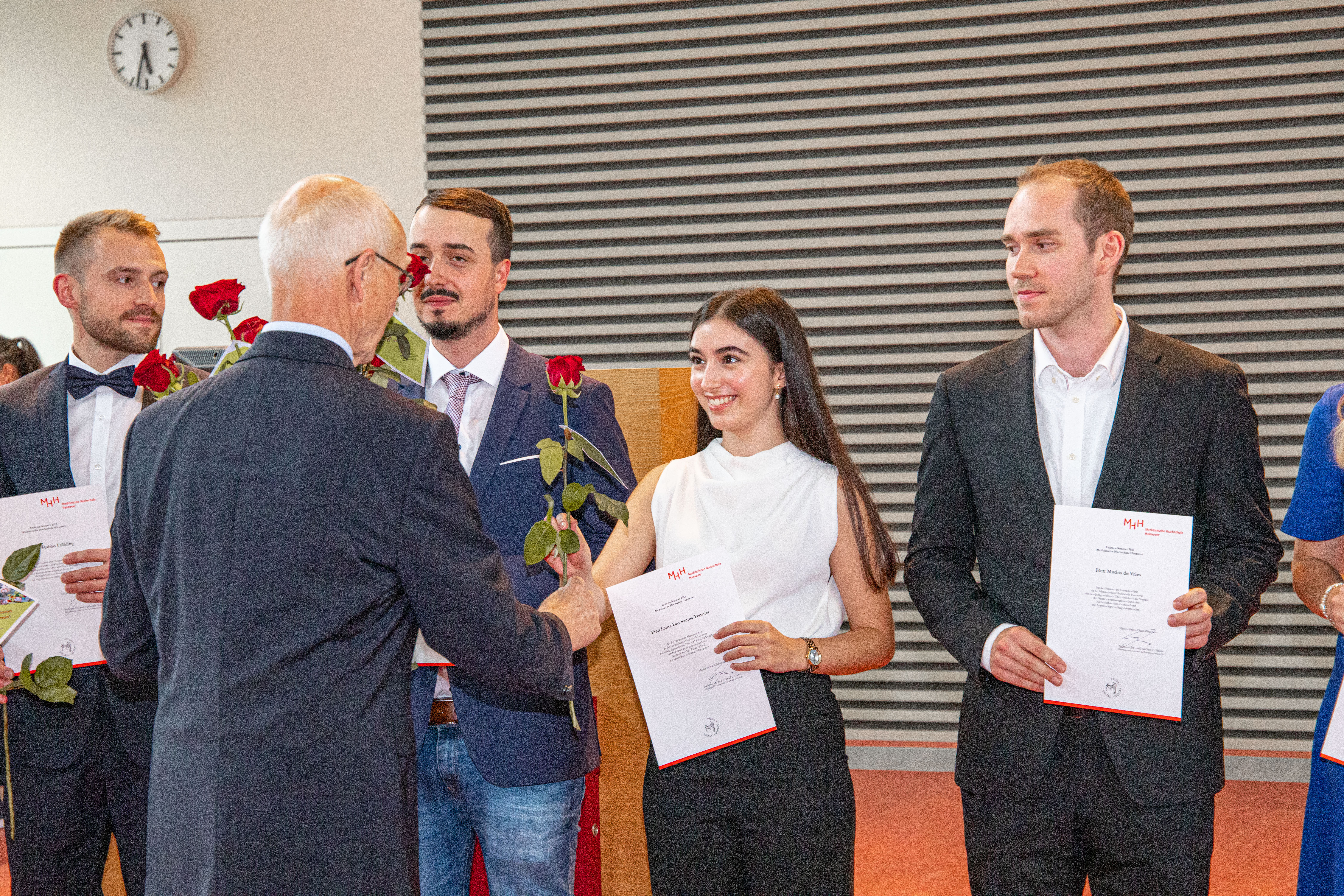 Alumni-Vorsitzender Prof. Dr. Piepenbrock übergibt eine rote Rose des Ehemaligenvereins an die Alumnis