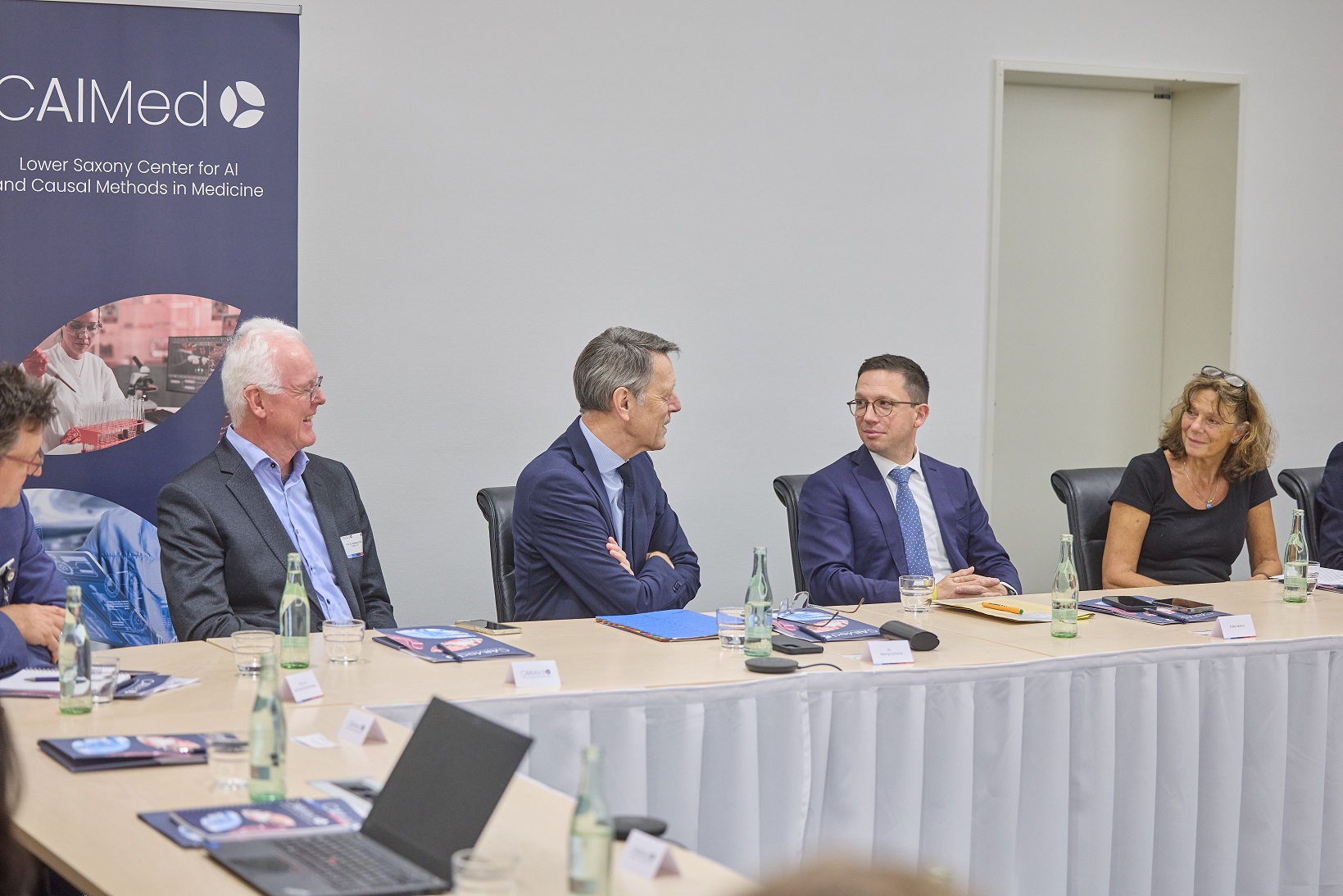Wolfgang Nejdl, Falko Mohrs, Dr. Georg Schütte und Prof. Dr. Denise Hilfiker-Kleiner sitzen nebeneinander in einem Konferenzraum 